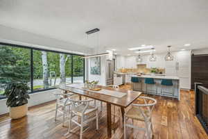 Dining room featuring light hardwood / wood-style floors, a barn door, and a textured ceiling