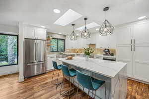 Kitchen featuring pendant lighting, a wealth of natural light, a skylight, and high end fridge