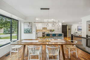 Dining room featuring light wood-type flooring, crown molding, and a barn door