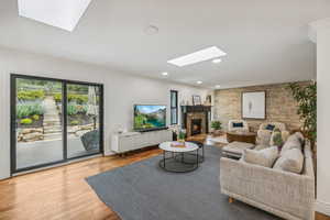 Living room with a skylight and hardwood / wood-style flooring