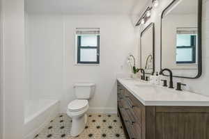 Bathroom with vanity, a healthy amount of sunlight, and toilet