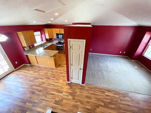 Kitchen featuring lofted ceiling, kitchen peninsula, and a healthy amount of sunlight