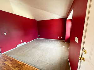 Bonus room featuring vaulted ceiling and dark wood-type flooring