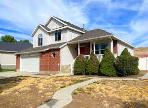 View of front of property featuring a garage and a porch