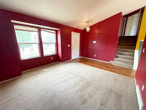 Spare room with a textured ceiling, lofted ceiling, and hardwood / wood-style flooring