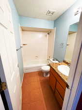 Full bathroom with washtub / shower combination, a textured ceiling, vanity, and toilet