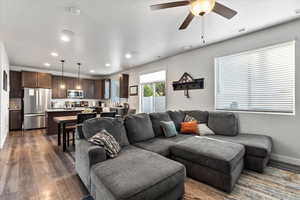 Living room with dark hardwood / wood-style floors and ceiling fan