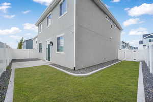 Rear view of property with a fenced backyard, stucco siding, and a gate