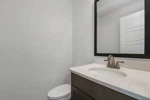 Half bathroom with vanity and toilet