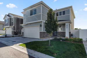 View of front of property with a garage and a front lawn