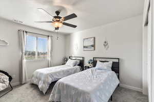 Bedroom featuring a textured ceiling, light carpet, and ceiling fan