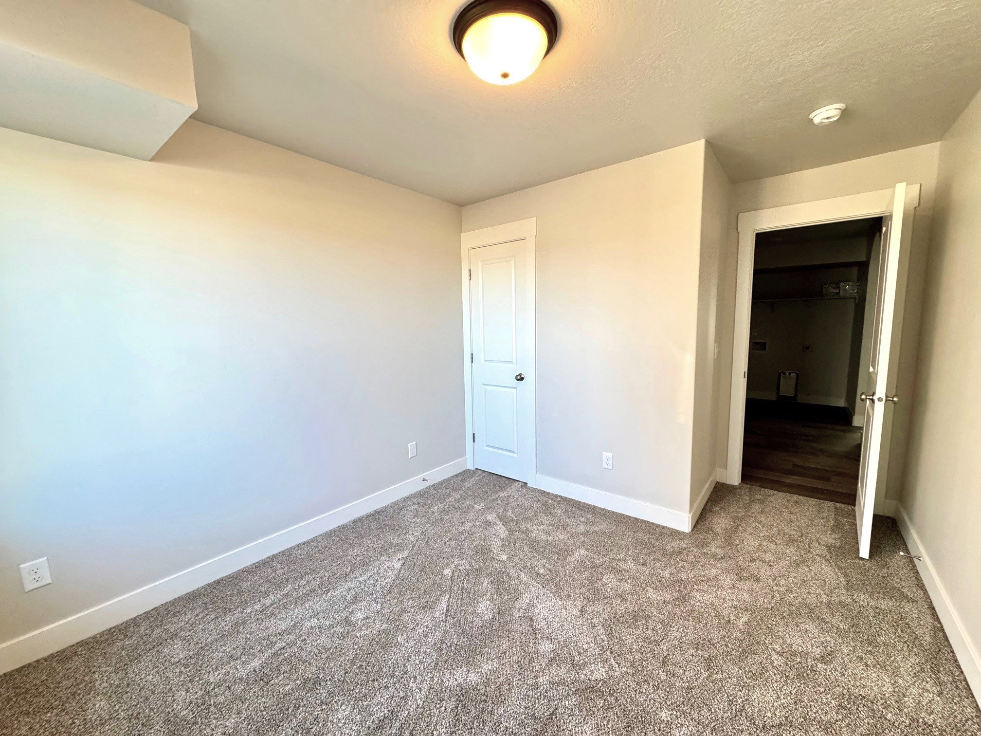 Unfurnished bedroom with a textured ceiling and carpet flooring
