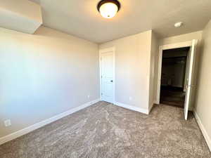 Unfurnished bedroom with a textured ceiling and carpet flooring