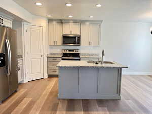 Kitchen featuring gray cabinetry, stainless steel appliances, and sink