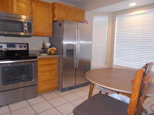 Kitchen with stainless steel appliances and light tile patterned floors