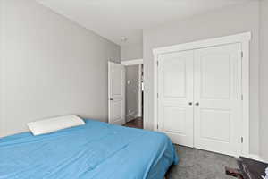 Carpeted bedroom featuring a closet