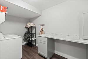 Interior space with washer and clothes dryer, cabinets, and dark hardwood / wood-style floors