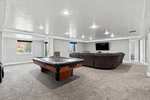 Playroom with a textured ceiling, light colored carpet, and billiards