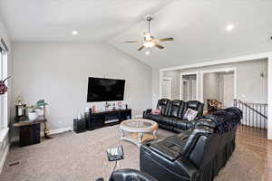 Living room featuring lofted ceiling, hardwood / wood-style flooring, and ceiling fan