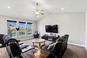 Carpeted living room with lofted ceiling and ceiling fan