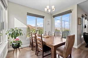 Dining room with a mountain view, an inviting chandelier, and hardwood / wood-style floors