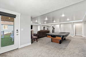 Game room featuring a textured ceiling, light colored carpet, and billiards