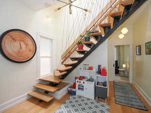 Stairway featuring a high ceiling and hardwood / wood-style floors