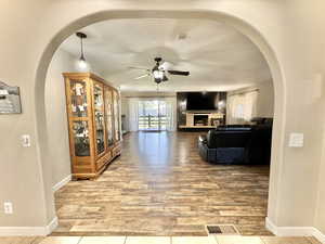 Living room featuring ceiling fan, hardwood / wood-style flooring, and a textured ceiling