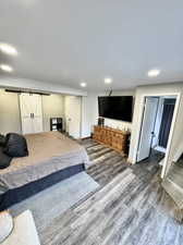 Bedroom featuring a barn door and dark hardwood / wood-style flooring