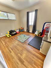 Workout room featuring a textured ceiling and light hardwood / wood-style flooring