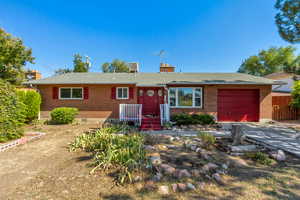 Single story home featuring central AC unit and a garage