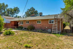 Back of property featuring a lawn and central air condition unit