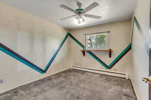 Empty room with a textured ceiling, light carpet, baseboard heating, and ceiling fan