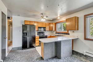 Kitchen with black appliances, kitchen peninsula, ceiling fan, and a wealth of natural light