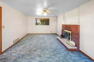 Second living room featuring carpet, ceiling fan, a fireplace, and a textured ceiling