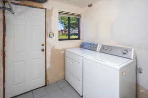 Washroom featuring light tile patterned floors and washer and clothes dryer