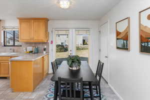 Dining room featuring sink, a textured ceiling, and french doors