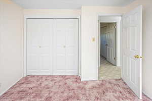 Bedroom with light carpet and a closet