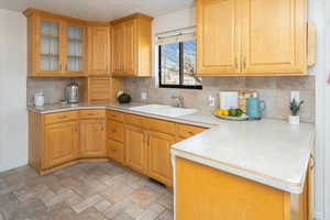 Kitchen featuring decorative backsplash, kitchen peninsula, and sink