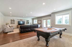 Recreation room with light hardwood / wood-style flooring, a textured ceiling, billiards, and french doors