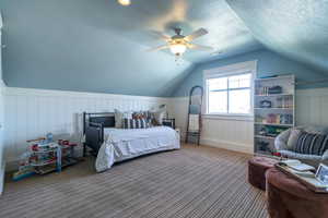 Bedroom with carpet, lofted ceiling, ceiling fan, and a textured ceiling