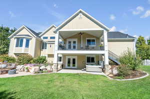 Back of house with ceiling fan, french doors, a yard, and a patio area