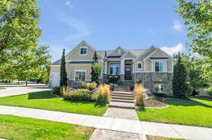 Craftsman house with a garage and a front lawn