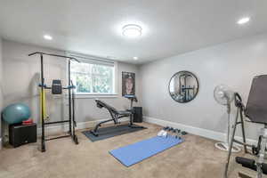 Exercise area with a textured ceiling and light carpet