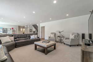 Living room featuring a textured ceiling and light colored carpet shiplap wall