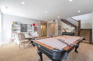 Recreation room featuring pool table, a textured ceiling, and light colored carpet