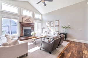 Living room featuring ceiling fan, plenty of natural light, hardwood  flooring, and a tile fireplace