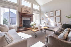 Living room with high vaulted ceiling and a healthy amount of sunlight