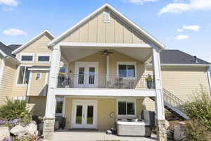 Rear view of property with a patio area, a balcony, a hot tub, ceiling fan, and french doors