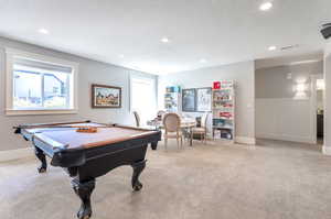 Playroom with light colored carpet, a textured ceiling, and pool table